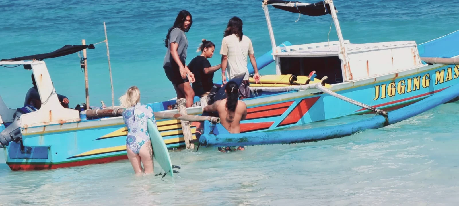 Surfboards beside a traditional jukung outrigger on a Bali beach