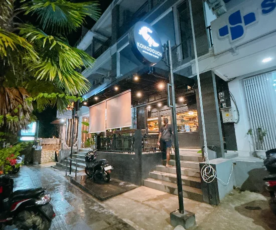 KOMODOUGH Artisan Bakery and Coffee storefront at night on Jalan Soekarno Hatta, the main strip in Labuan Bajo
