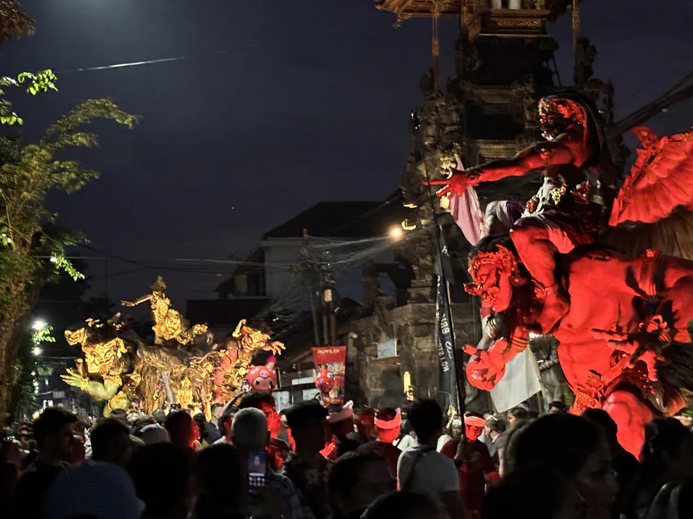A large red winged demon Ogoh-Ogoh effigy lit up above the crowd on Nyepi eve in Kuta, Bali