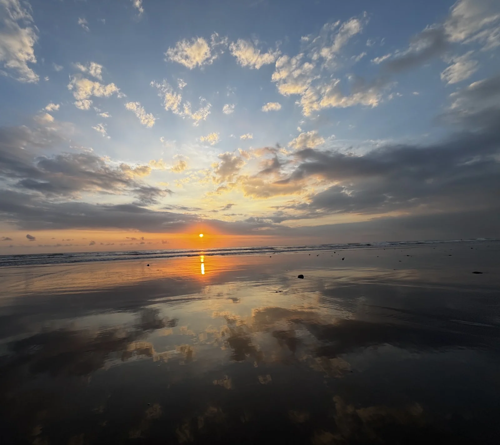 Sunset reflected on the wet sand at Seminyak Beach, Bali
