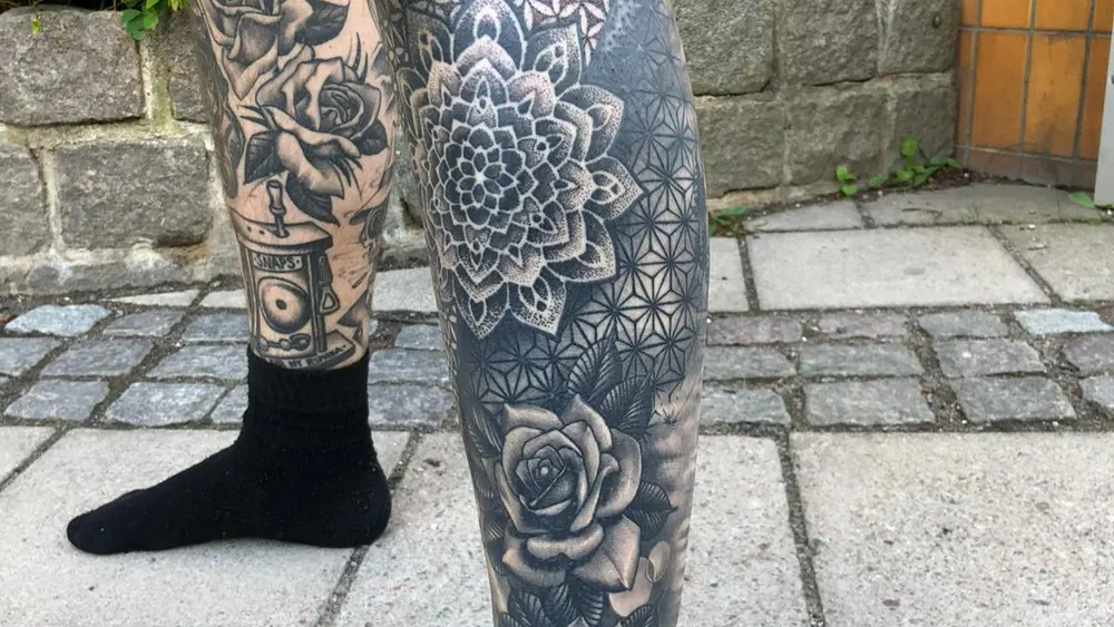 A black-and-grey mandala and sacred-geometry leg sleeve tattooed at a Kuta studio in Bali
