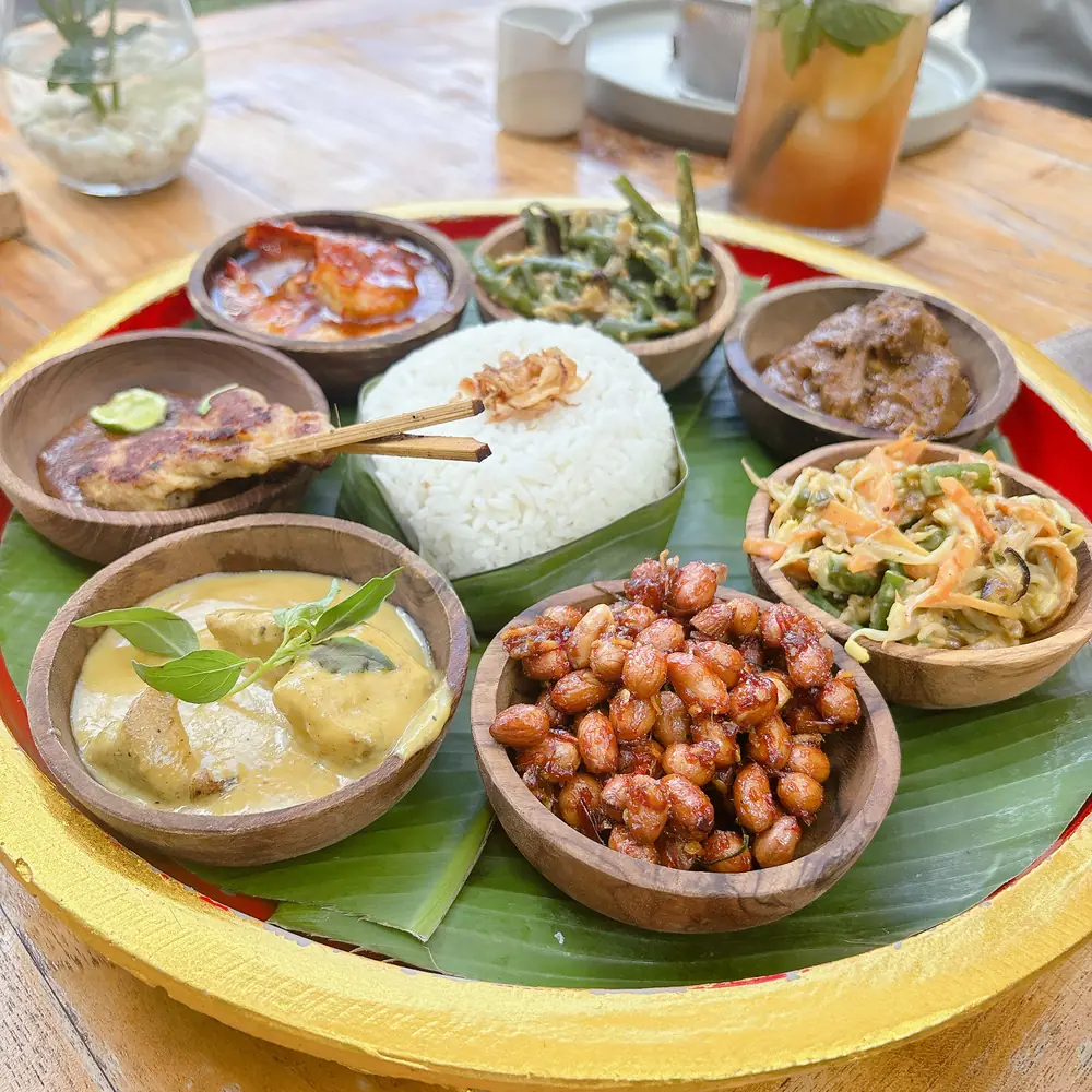 An Indonesian nasi campur platter with rice, sambal, vegetables and peanuts on a banana leaf at TIS Cafe near Ubud, Bali