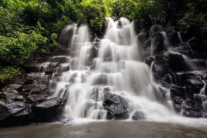 Kanto Lampo Waterfall near Ubud, Bali, with water fanning over a stepped black rock face
